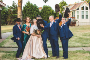 Bride and groom kissing and bridal party cheering