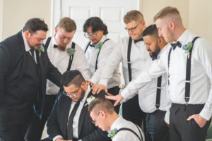 Groomsmen praying over groom