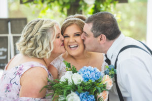 Parents kissing bride