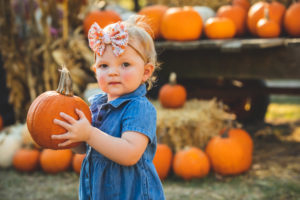 little girl holding a pumpkin