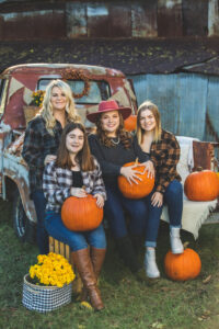 Family sitting on truck with pumpkins